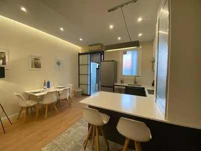 a kitchen with a counter and a table and chairs at Spatious luxe apartment Paseo de Gracia Diagonal in Barcelona