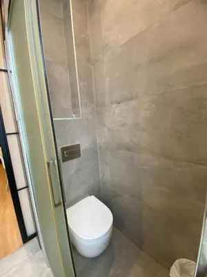 a small bathroom with a toilet in a stall at Spatious luxe apartment Paseo de Gracia Diagonal in Barcelona