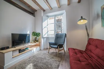 a living room with a red couch and a television at Welcomy Born in Barcelona