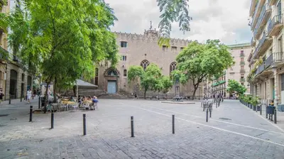 a street with people sitting at tables in front of a building at Welcomy Born in Barcelona