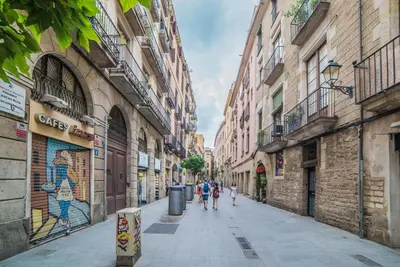 a group of people walking down a street with buildings at Welcomy Born in Barcelona