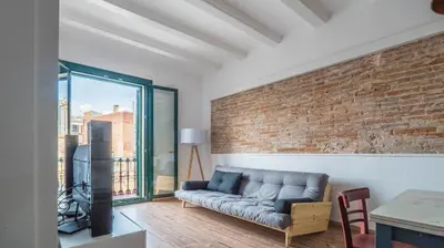 a living room with a couch and a brick wall at Welcomy Poblenou II in Barcelona