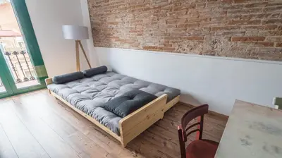 a couch in a room with a brick wall at Welcomy Poblenou II in Barcelona