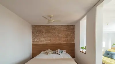 a bedroom with a brick wall and a bed at Welcomy Poblenou II in Barcelona
