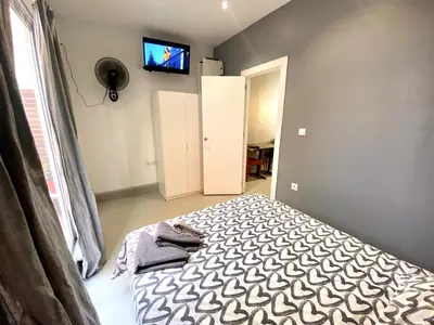 a bedroom with a bed and a tv on the wall at Apartamento de 3 habitaciones en Sants a 2`del metro Badal P9 in Barcelona