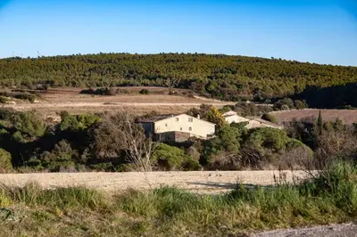 a house on a hill in the middle of a field at Can Vidal in Subirats