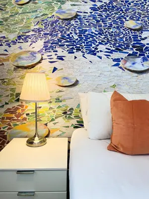 a bed with a lamp on a night stand next to a mural at Boutique Pare Lainez- 2 BR Sagrada Famlia with balcony in Barcelona