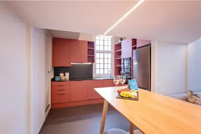 a kitchen with red cabinets and a table with a bowl of fruit at Sweett - Ethnic Eixample in Barcelona
