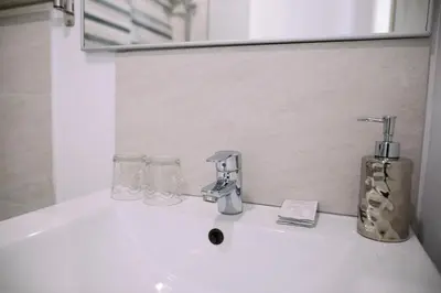 a bathroom sink with a faucet and a mirror at Hostal Eixample in Barcelona