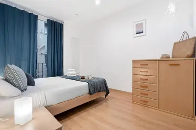 a bedroom with a bed and a dresser and a window at Lodging Apartments Villarroel apartment in Barcelona