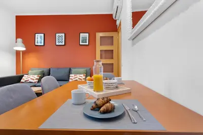 a table with a plate of food and a glass of orange juice at Lodging Apartments Villarroel apartment in Barcelona