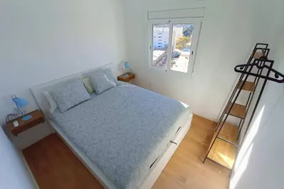 a bedroom with a bed and a ladder and a window at Ático cerca Playa y centro a 10 min. in Sant Adria de Besos