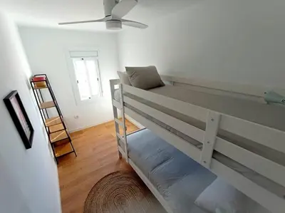 a bedroom with a bunk bed with a ladder in it at Ático cerca Playa y centro a 10 min. in Sant Adria de Besos