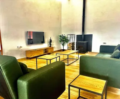 a living room with two green couches and a fireplace at jacuzzi privado con vistas increíbles el Raco d Artes in Artés