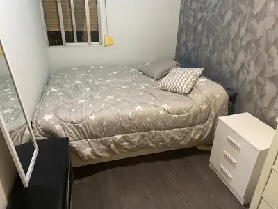 a small bed in a small room with a silver bedspread at Habitaciones cerca del centro de Barcelona, Barceloneta, Aeropuerto y Fira in Hospitalet de Llobregat