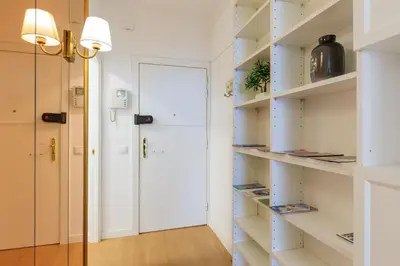 a room with white shelves and a door at ApartEasy - Private terrace, 3 bedrooms, Eixample in Barcelona