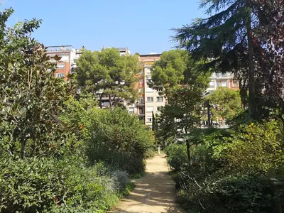 a path through a city with buildings in the background at ApartEasy - Private terrace, 3 bedrooms, Eixample in Barcelona