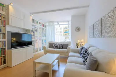 a living room with a couch and a tv at ApartEasy - Private terrace, 3 bedrooms, Eixample in Barcelona