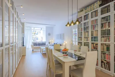 a dining room with a table and chairs and bookshelves at ApartEasy - Private terrace, 3 bedrooms, Eixample in Barcelona