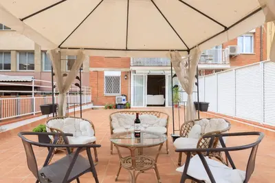 a patio with a table and chairs and a umbrella at ApartEasy - Private terrace, 3 bedrooms, Eixample in Barcelona