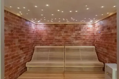 a bench in a room with a brick wall at Hotel Sorli Emocions in Vilassar de Dalt