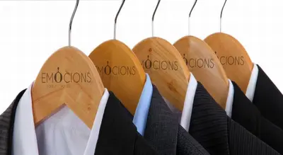 a row of wooden hangers in a closet at Hotel Sorli Emocions in Vilassar de Dalt