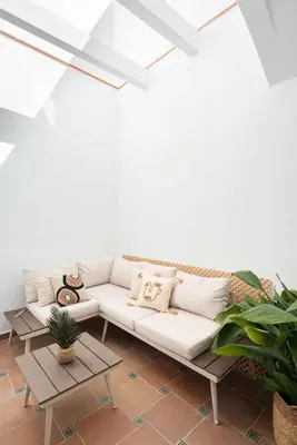 a living room with a white couch and two tables at Casa familiar junto al mar en Arenys de Mar in Arenys de Mar
