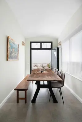 a dining room with a wooden table and chairs at Casa familiar junto al mar en Arenys de Mar in Arenys de Mar