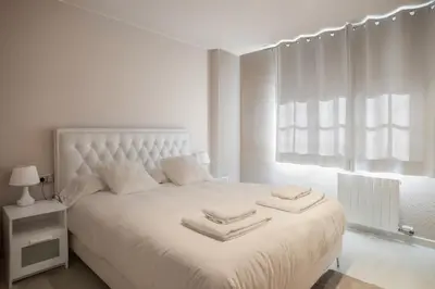 a bedroom with a white bed with towels on it at Comodidad y estilo en Gava near the beach 10 minutes in Viladecáns