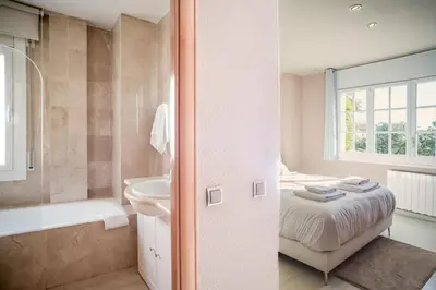 a bathroom with a bed and a tub and a sink at Comodidad y estilo en Gava near the beach 10 minutes in Viladecáns