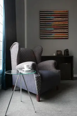a living room with a chair and a glass table at Amra Barcelona Gran Via in Barcelona