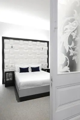 a bedroom with a white bed with a large headboard at Amra Barcelona Gran Via in Barcelona