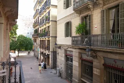 a group of people walking down a street next to buildings at Easysleep Borne in Barcelona