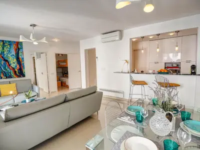 a living room with a couch and a glass table at Aolani Apartment by Hello Homes Sitges in Sitges