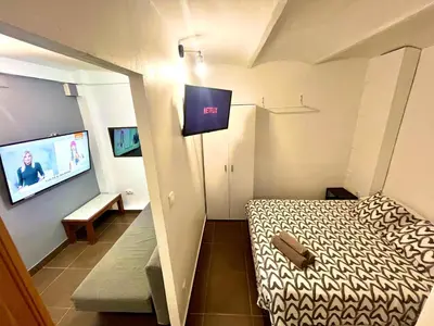a small room with a bed and a flat screen tv at B3 planta baja al lado del metro in Barcelona