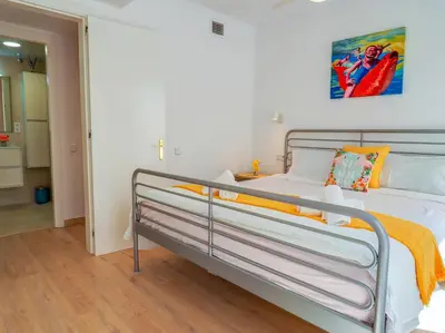 a bedroom with a metal bed with an orange blanket at Happy Diamond by Hello Homes Sitges in Sitges