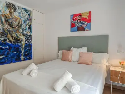 a bedroom with a bed with towels on it at Happy Diamond by Hello Homes Sitges in Sitges