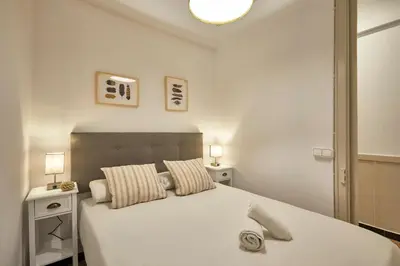 a bedroom with a large white bed with two night stands at BBarcelona Sagrada Familia Garden Apartment in Barcelona