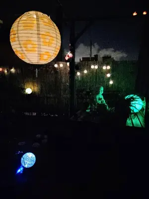 a person sitting under a tent at night with lanterns at Atico Soleado in Esplugues de Llobregat