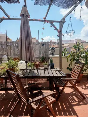a patio table with an umbrella and two chairs at Atico Soleado in Esplugues de Llobregat