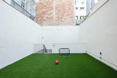 a soccer ball on a green field in an empty building at YOUR HOME- Apartment Camp Nou Baj in Hospitalet de Llobregat