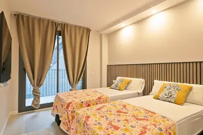 a hotel room with two beds and a window at YOUR HOME- Apartment Camp Nou 1 in Hospitalet de Llobregat