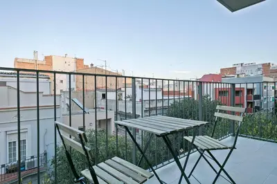 a table and two chairs on a balcony with a city at YOUR HOME- Apartment Camp Nou 2b in Hospitalet de Llobregat