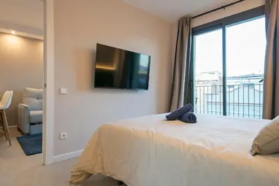 a bedroom with a bed with a tv on the wall at YOUR HOME- Apartment Camp Nou 2b in Hospitalet de Llobregat