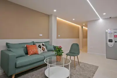 a living room with a green couch and a table at YOUR HOME- Apartment Camp Nou 2b in Hospitalet de Llobregat