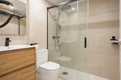 a bathroom with a toilet and a glass shower at YOUR HOME- Apartment Camp Nou 2b in Hospitalet de Llobregat