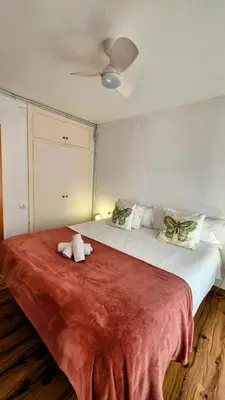 a bedroom with a large bed with a red blanket at Vila Sitges, big house with pool in Sitges