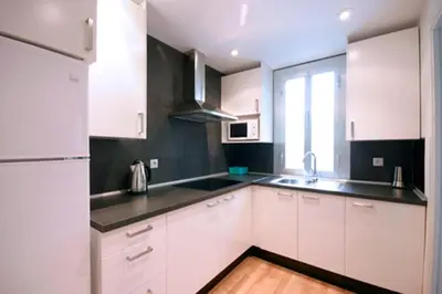 a white kitchen with white cabinets and a window at Cosmopolitan in Barcelona