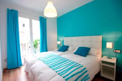 a blue bedroom with a large bed with blue curtains at Cosmopolitan in Barcelona