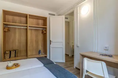 a bedroom with a white bed and a desk at AB Marina Apartments in Barcelona